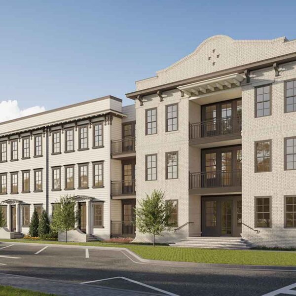 This image shows a new multi-story residential building with a beige and brown exterior, balconies, and a parking area in the foreground.