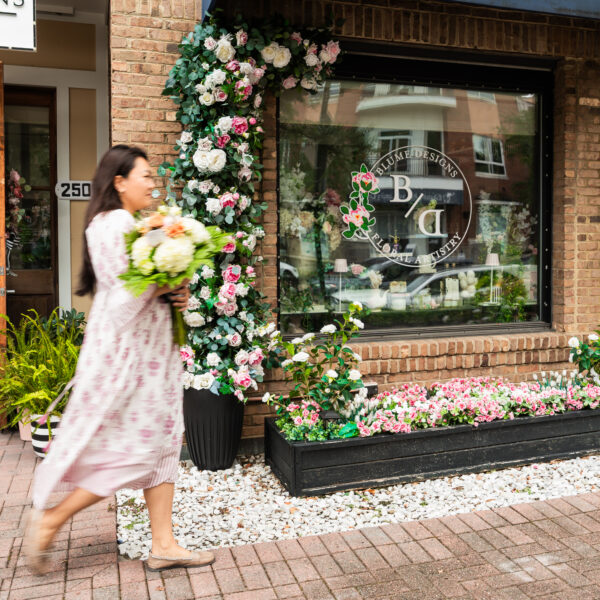 Resident walking past a local flower shop on Daniel Island carrying a bouquet of fresh florals.