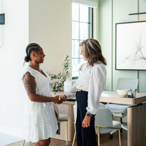 Resident greeting the leasing team inside the bright, airy clubhouse at Atlantic Nowell Creek.