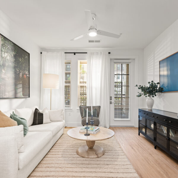 Open living area showcasing a neutral color palette, and access to a private patio.