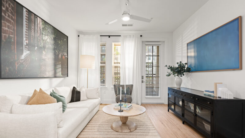 Open living area showcasing a neutral color palette, and access to a private patio.