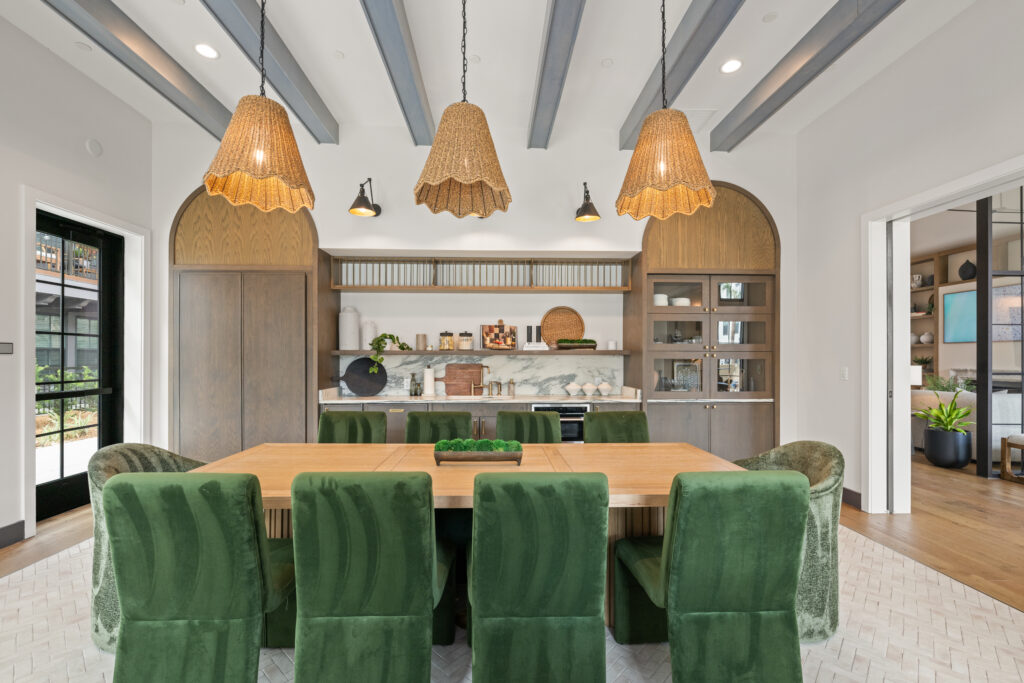 Entertainment kitchen in clubroom with green chairs and dining table.