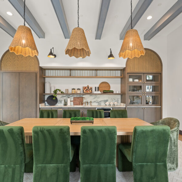 Entertainment kitchen in clubroom with green chairs and dining table.