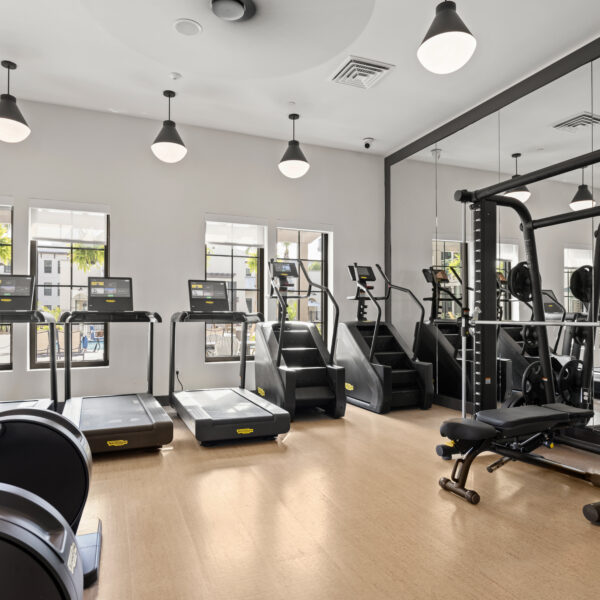 Fitness center with cardio equipment and ample natural light