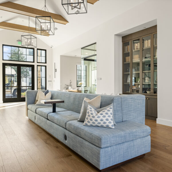 Bright common area featuring expansive windows, wood flooring, and multiple seating areas designed for gathering and relaxation.