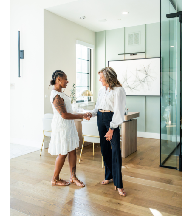 Two people meeting and shaking hands in the leasing office