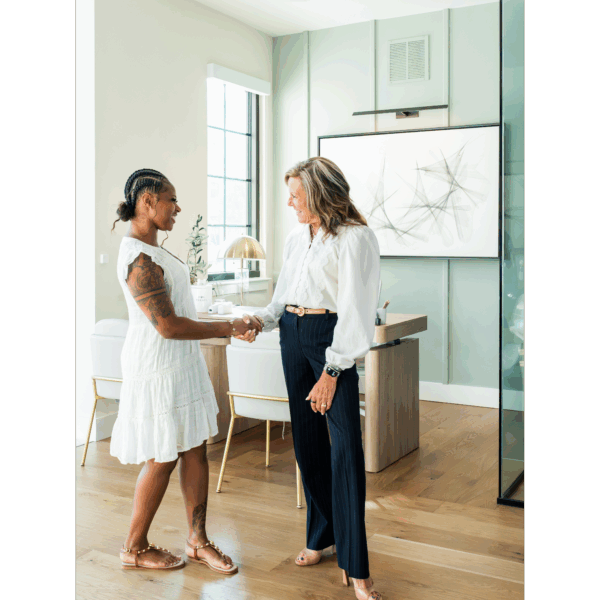 Two people meeting and shaking hands in the leasing office